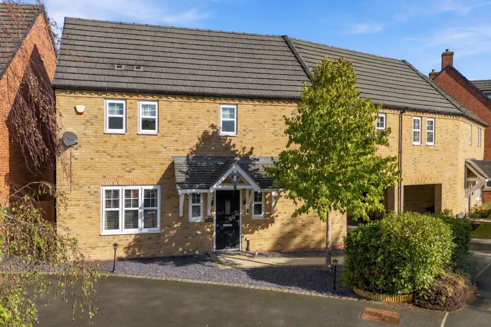 Brick family home with a tree-lined driveway