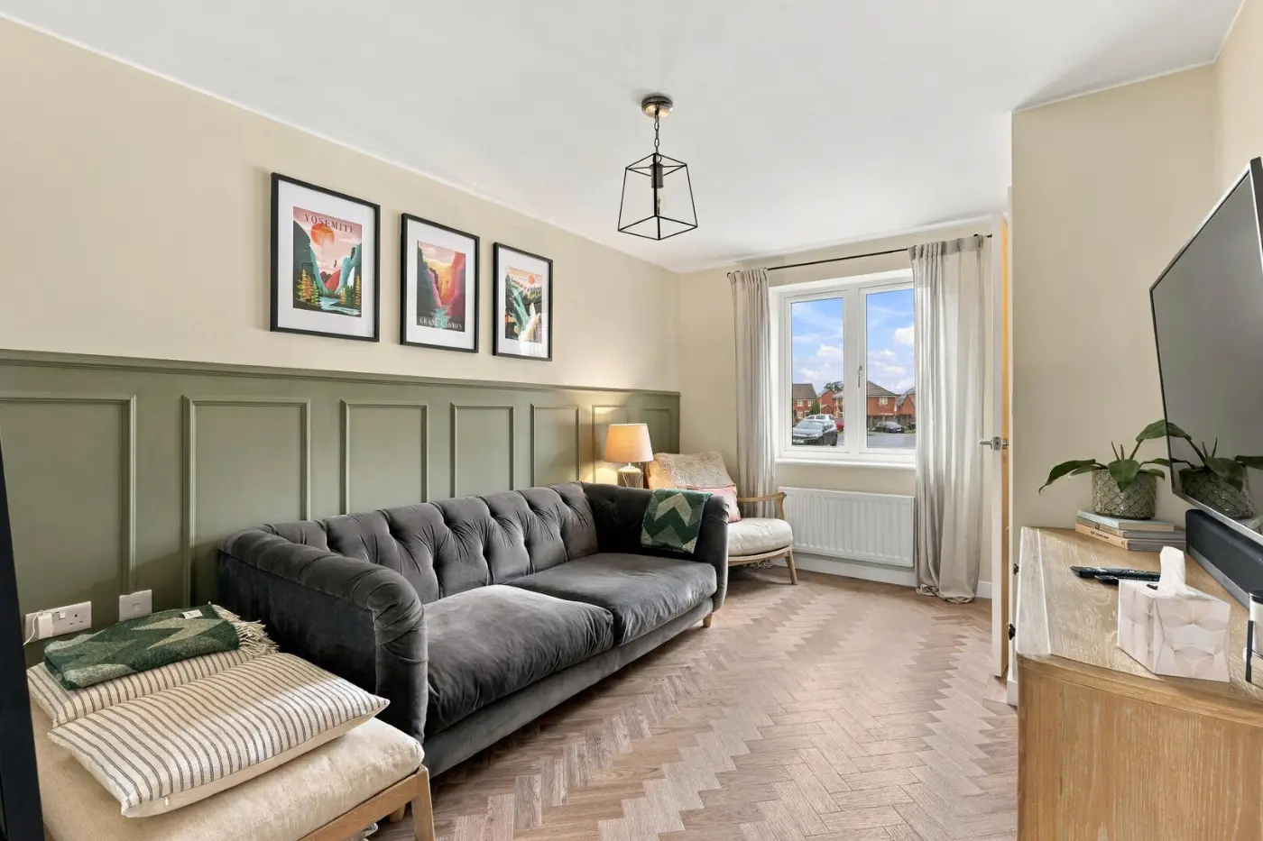 Living room with a grey sofa and green wall panelling